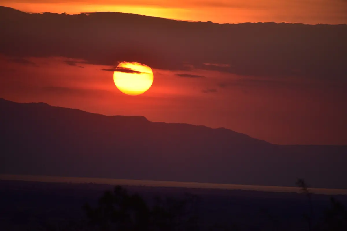 Orangefarbene Sonne geht über der Grabenbruchstufe unter, gesehen vom Tarangire